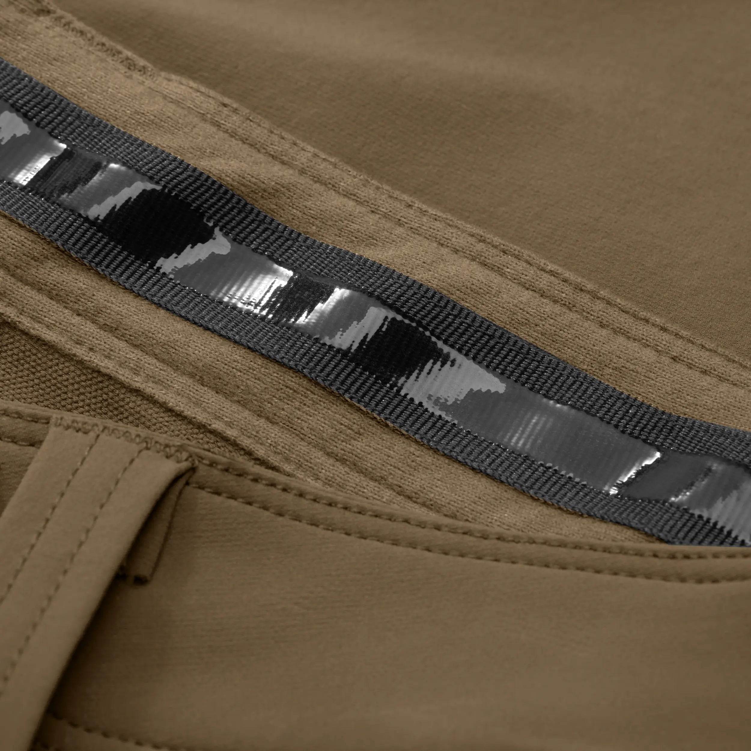 Close-up of rubber material waistband on tan pant. #field_khaki