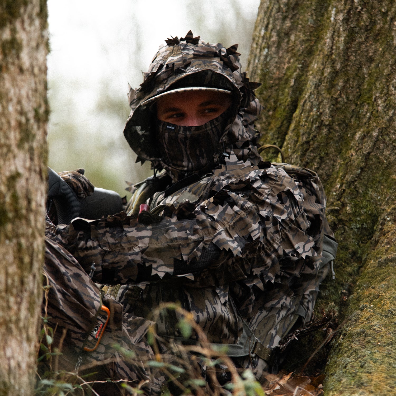 Person in full camouflage gear blending into a natural setting