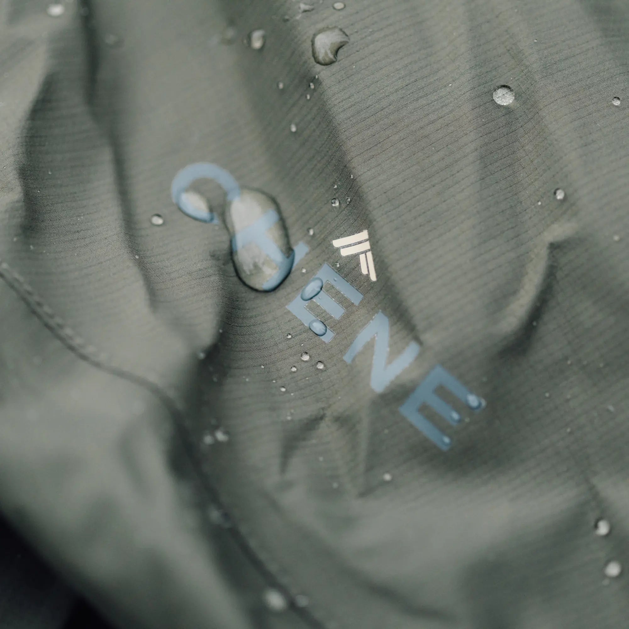 Close-up of a water droplet on a textured surface with a brand logo. #cypress