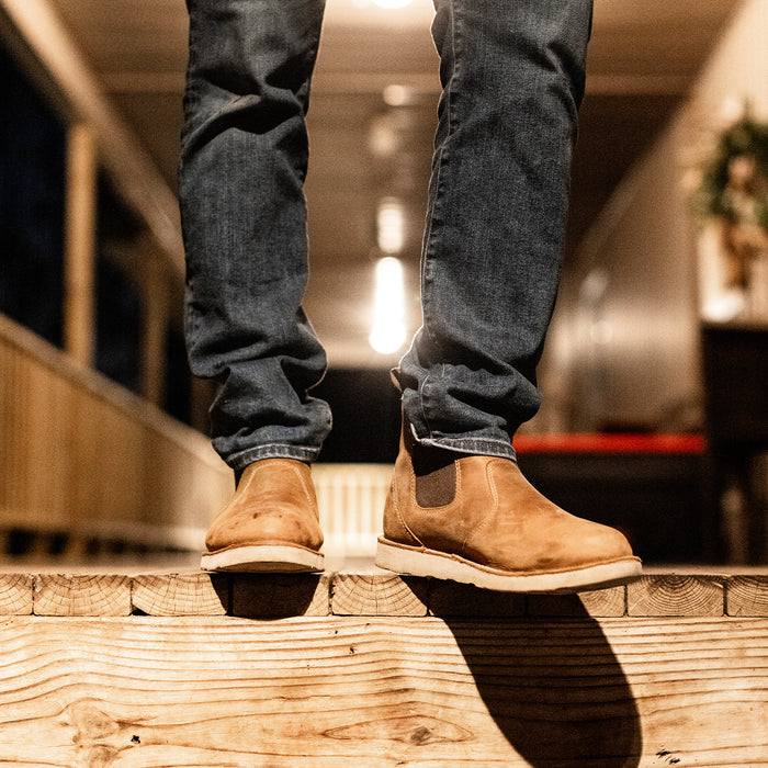 a person's legs standing on a wooden platform