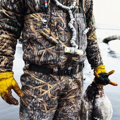 a person in camouflage holding a duck